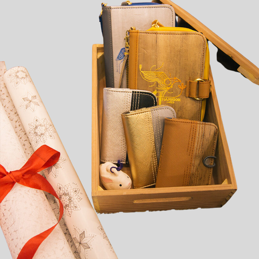 5 different vegan leather journals in different sizes, displayed on a wooden crate that is next to a roll of christmas gift wrapping paper.