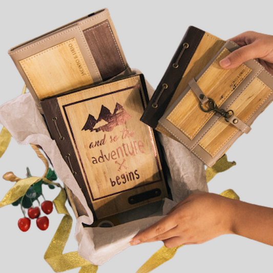 A gift set of 4 different kinds of vegan leather journals being tucked into a cardboard box.
