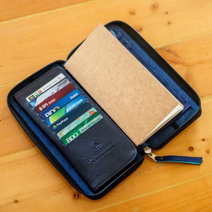 A rectangular blue leather wallet that has card slots and notebook pages inside.