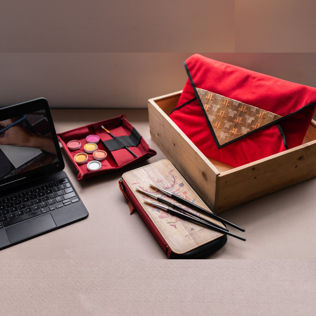A desktop of painting materials and an iPad showing a painting tutorial.