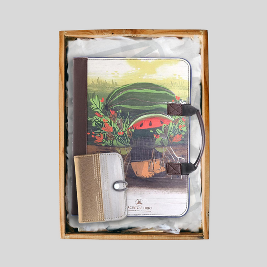 A gift set featuring a planner with a vibrant watermelon and plant design alongside a compact, mini vegan leather wallet inside a wooden crate.