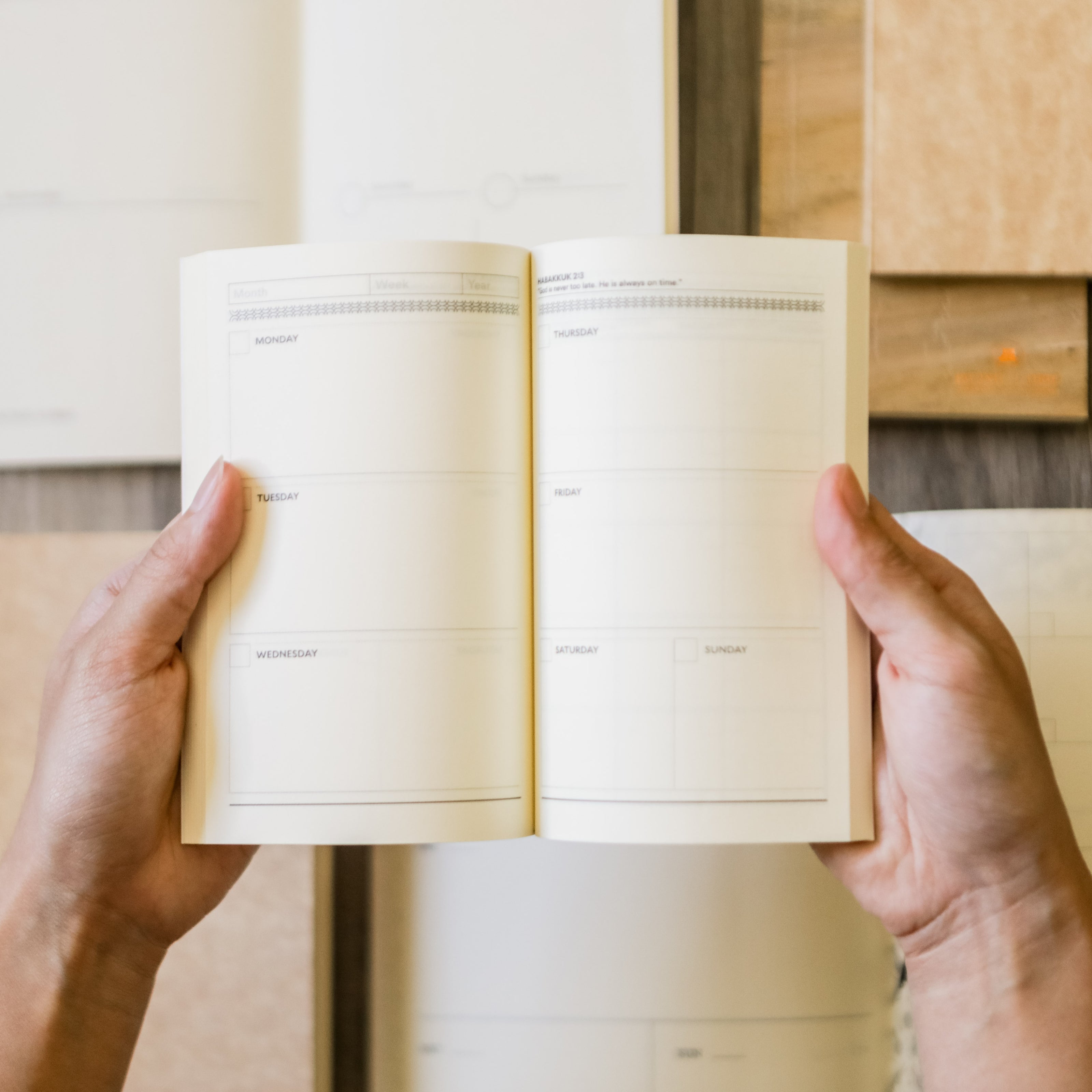 A person opening a planner notebook wide .