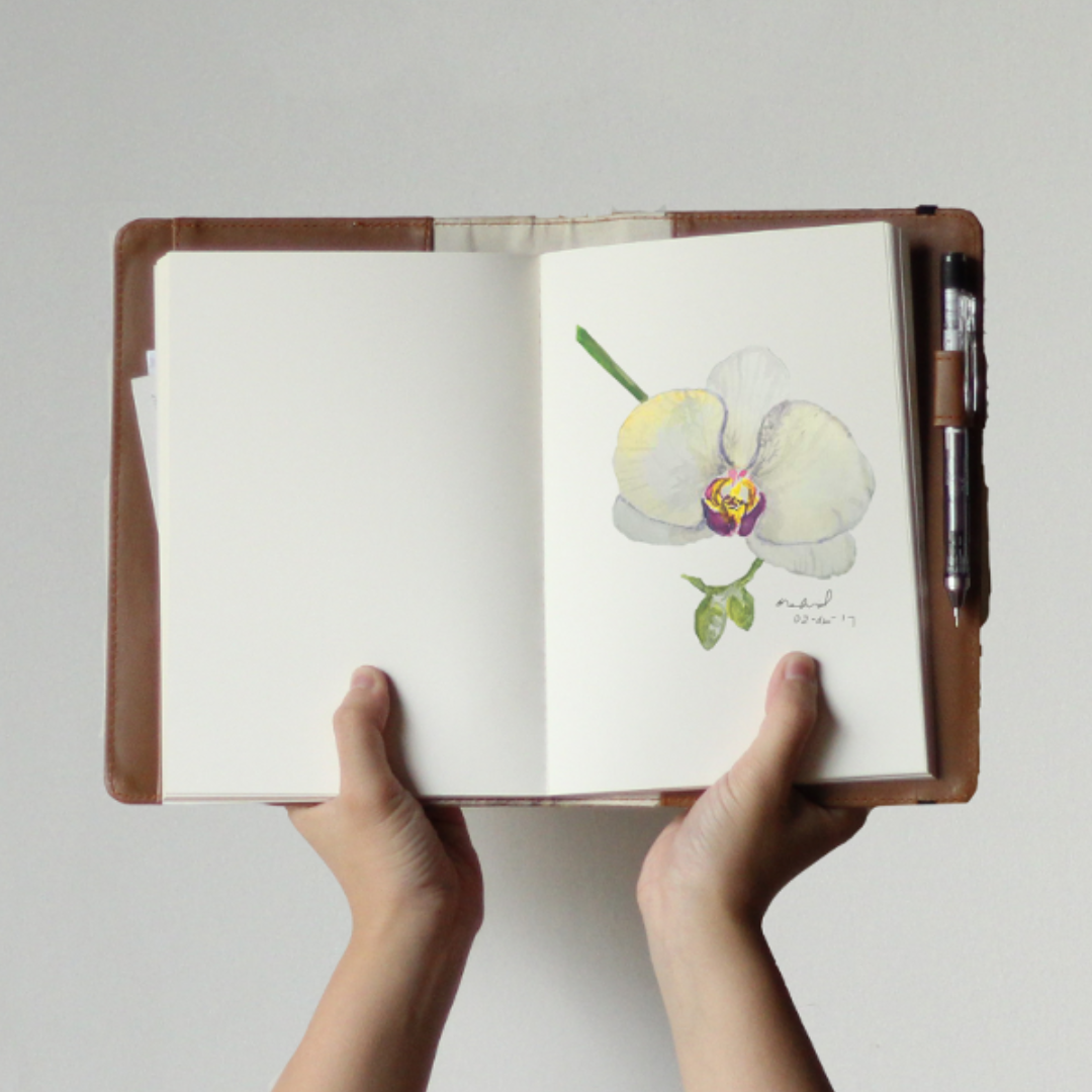 A drawing of an orchid inside a brown journal.