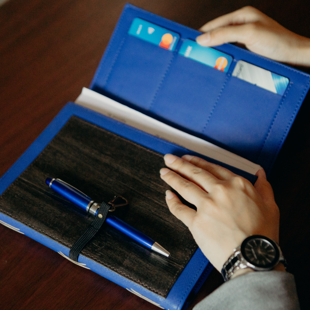 A person opening up a black and blue dual cover journal.