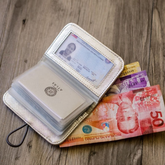 A white vegan leather card wallet with cards and IDs in it