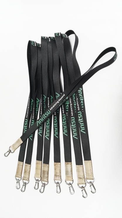 Group of black custom Anritsu lanyards with green logo, ideal for ID badges, corporate events, and promotional giveaways. Includes durable metal clips. Each lanyard featuring the green "Advancing Beyond" slogan, brown faux leather accents, and a silver swivel clip.