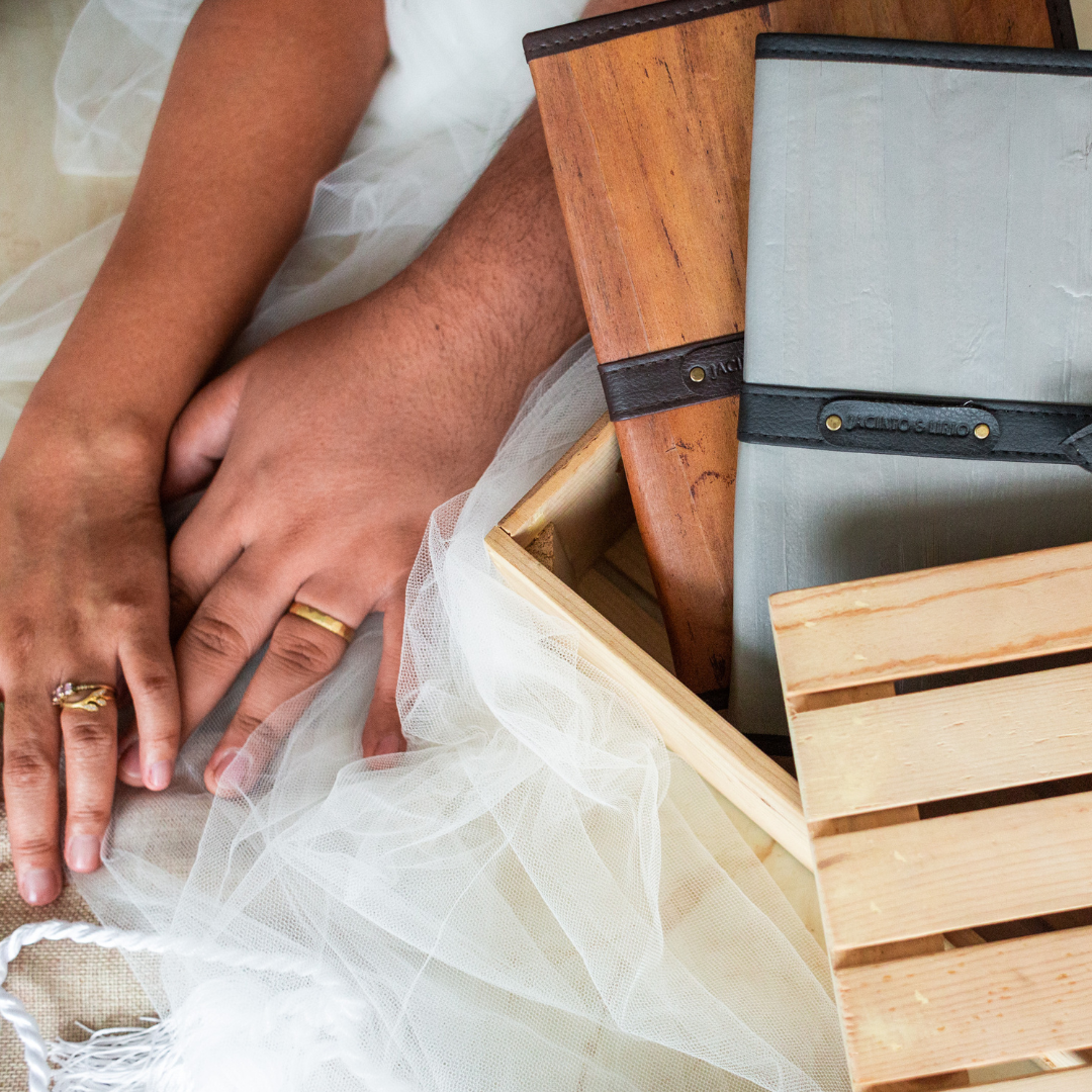 The hands of a couple next to a pair of journals.
