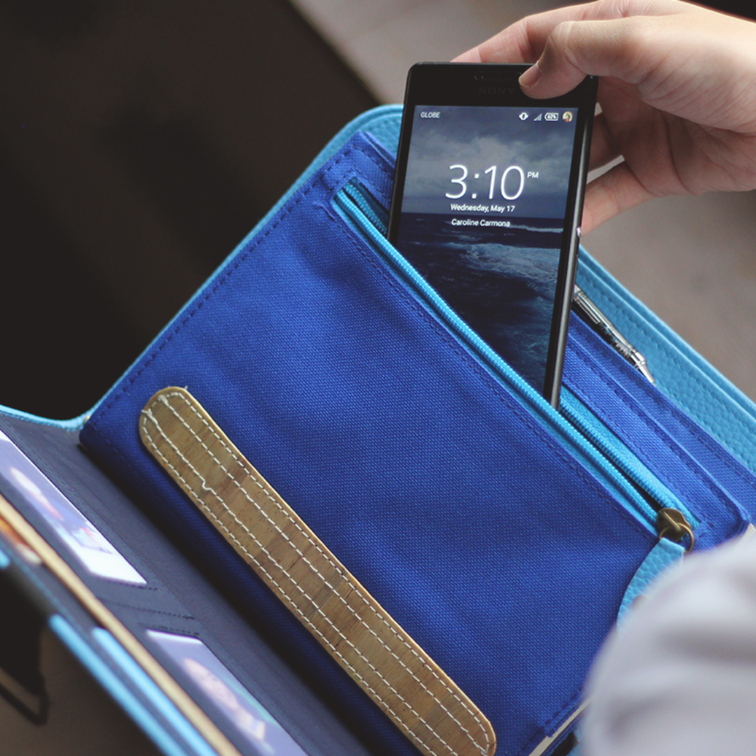 A phone being slipped into a blue pouch.