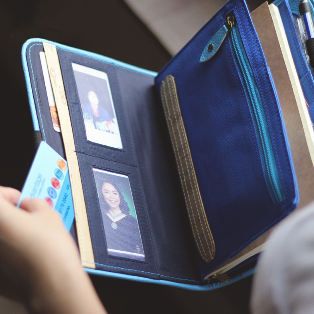 A blue wallet attached to a journal with card holders.