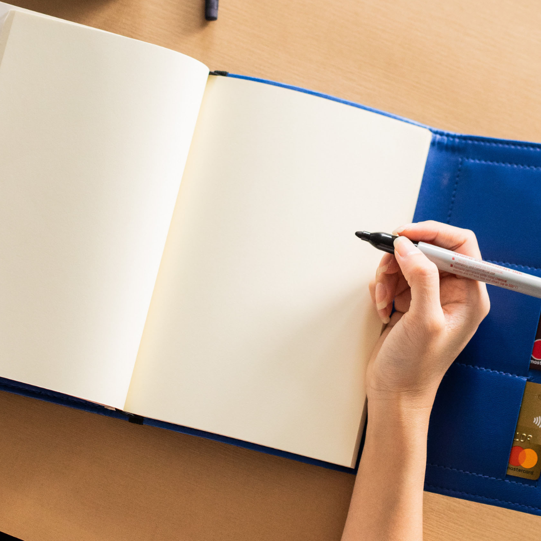 A person getting ready to write on blank pages.