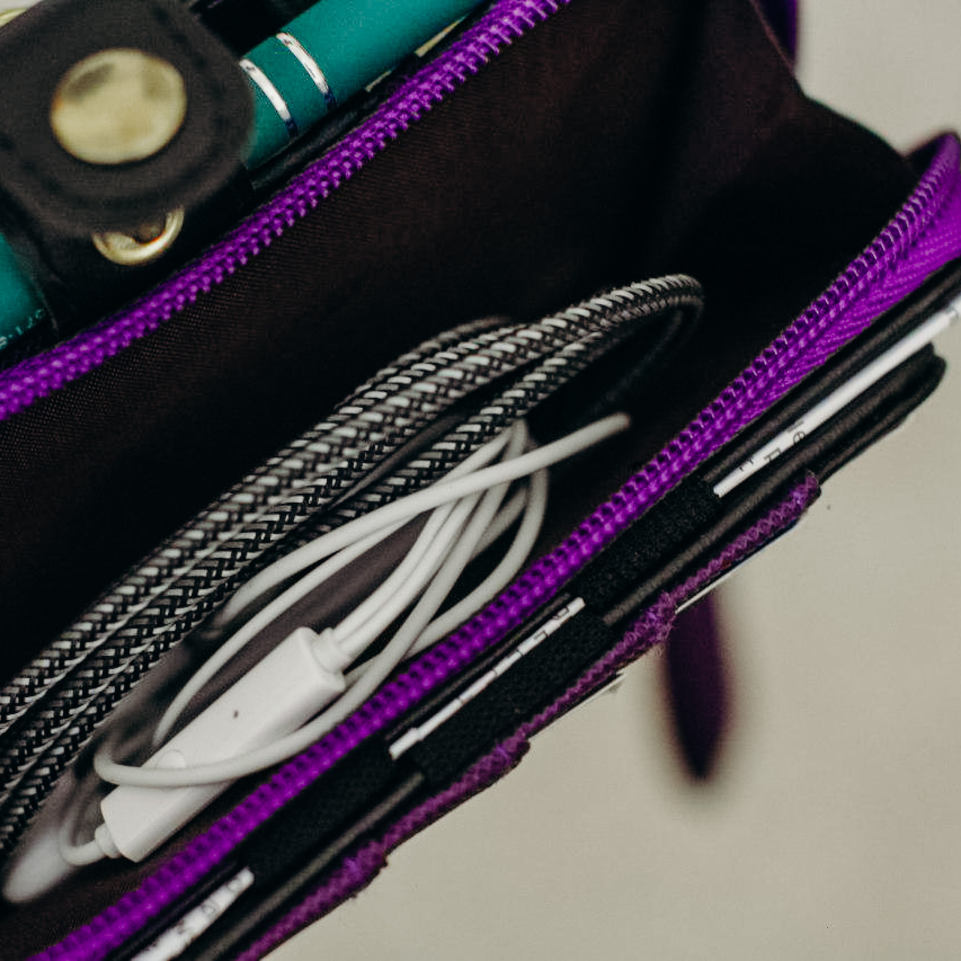 Charging cords being stored inside a purple purse.