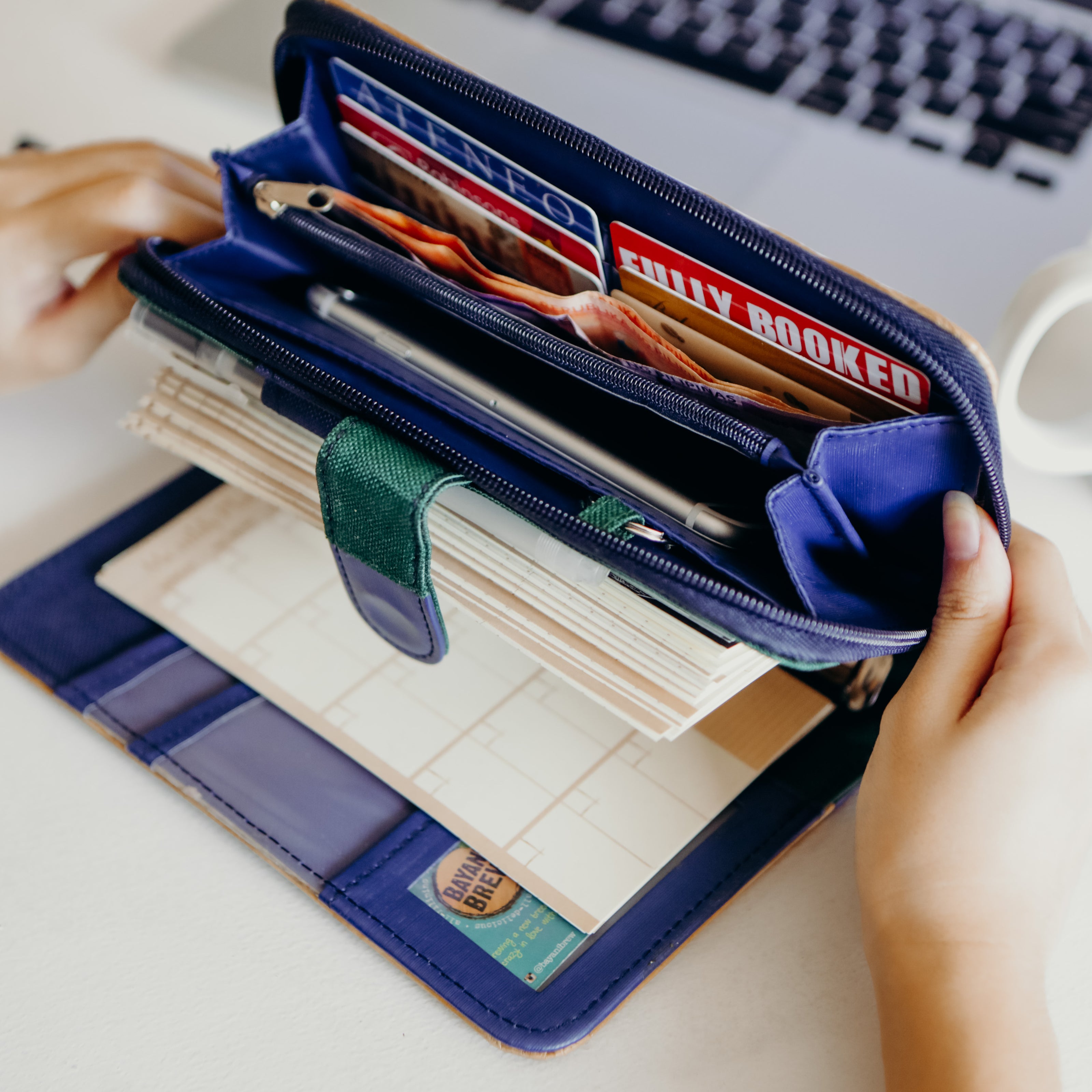 A blue vegan leather wallet with many cards and bills.